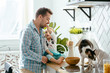 © Iryna - Father and daughter and their cat enjoying morning time together, cooking in the kitchen, family lifestyle. Multitasking and husework.