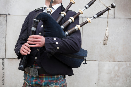 Fotografía Scottish bagpiper dressed in traditional dress performing on the street