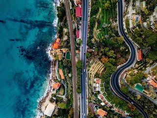 Wall Mural - Aerial view of road, highway and railway going along ocean or sea. Drone photography in rural Italy