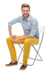 Wall Mural - young man sitting on a chair
