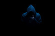 Man in black hood in the night darkness, dimly lit, concepts of danger, crime, terror