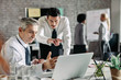 © Drazen - Two businessmen cooperating while working on laptop in the office.
