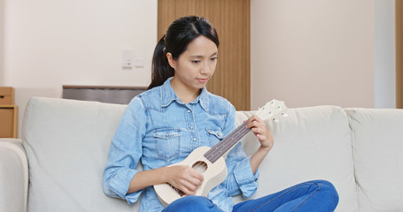 Canvas Print - Woman enjoy play with ukulele