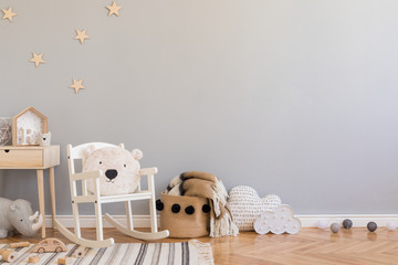 stylish scandinavian newborn baby room with toys, teddy bear on children's chair, natural basket wit