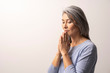 © Svyatoslav Lypynskyy - Mature Asian woman praying on white background