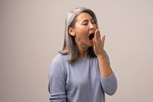 Tired Asian Woman Yawning In Photo Studio
