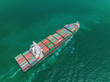 © Pawinee - Aerial view Container Ship full load container on the green sea for logistics, import export, shipping or transportation.