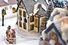 Christmas Decorating, small houses and people in snowy street
