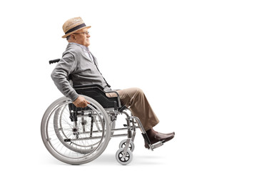 Wall Mural - Elderly man in a wheelchair pushing himself manually