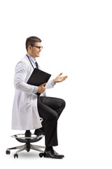 Wall Mural - Young male doctor sitting and gesturing a conversation