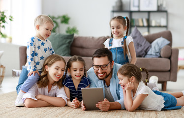 large family mother, father and children with tablet computer at home.