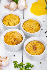 Wall Mural - Polenta with mushrooms in white ramekin bowls on wooden rustic table. Close up