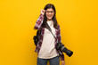 © luismolinero - Photographer teenager girl over yellow wall with glasses and surprised