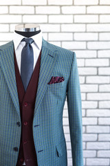 Wall Mural - Expensive custom tailored suit on male mannequin with urban trendy colors isolated on brick background