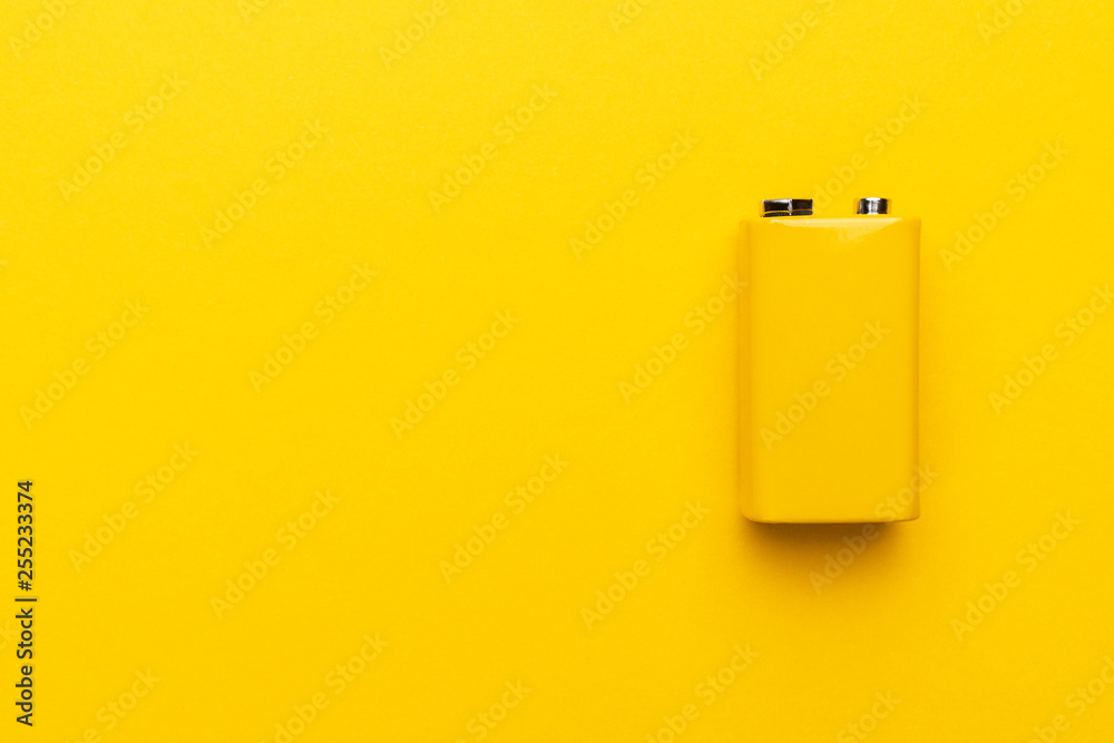 blank nine-volt battery on the yellow background with copy space - obrazy, fototapety, plakaty 