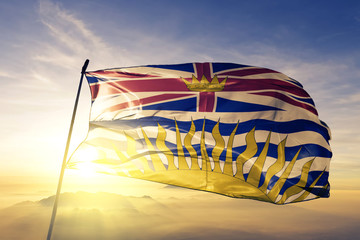 Poster - British Columbia province of Canada flag waving on the top sunrise mist fog