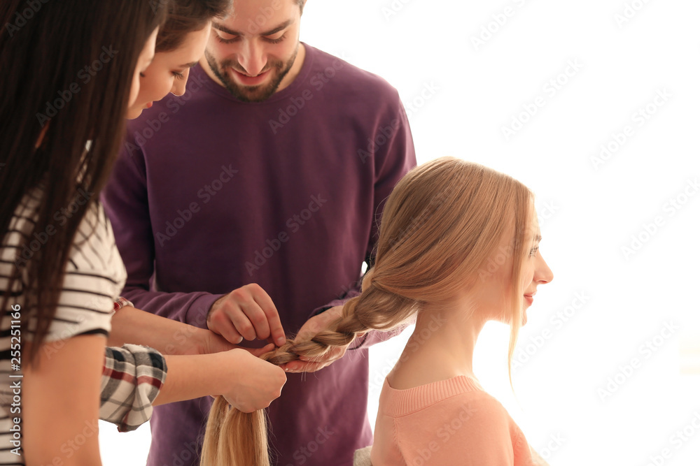 Professional hairdresser and trainees working with client in salon. Apprenticeship concept