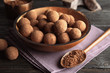 © New Africa - Plate with chocolate truffles on wooden background