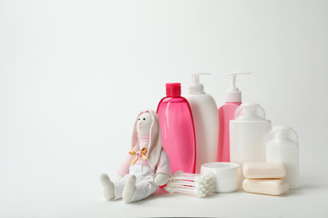 Wall Mural - baby cosmetic products, toy and cotton swabs on white background