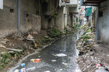 Dirty polluted waste water in big city with garbages. Environment pollution. Urban environment issues in developing countries