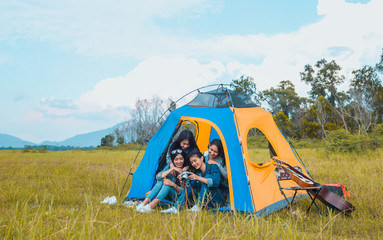 diversity young asian women camping and resting at forest looking a photo in camera happy on weekend