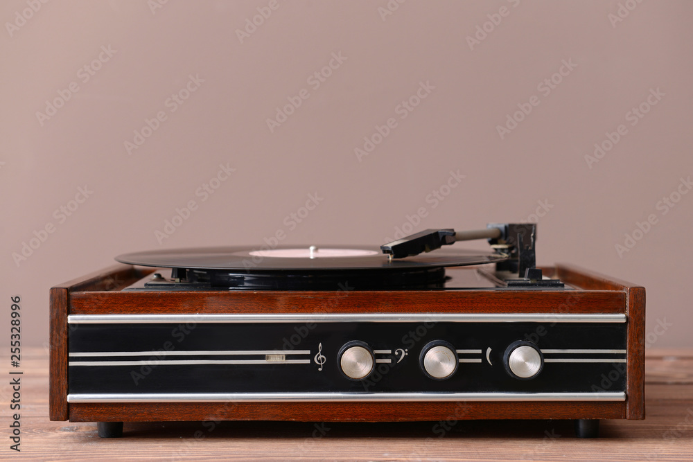 Record player with vinyl disc on table