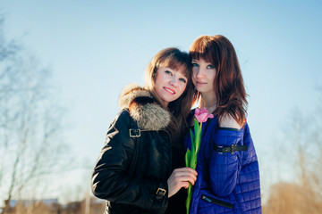 Wall Mural - Portrait of two beautiful girls against a clear spring sky