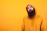 Fototapeta  - Portrait of Bearded man looking serios at the camera over yellow background