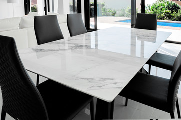 Luxurious marble dining table with black chairs.