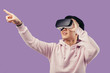© alfa27 - Amazed positive chinese male gamer wearing virtual reality goggles headset, vr box, posing isolated in studio over violet background. Connection, technology, new generation, progress concept.