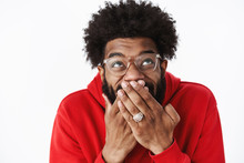 Waist-up Shot Of Delighted Happy African American Male Bearded Friend In Glasses Chuckling, Giggling With Hand Covering Mouth Looking Up Amused Awaiting For Prank Come In Action, Joking Over Friend