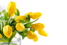 A Bouquet Of Yellow Tulip Flowers In Glass Vase On White Background. A Gift To A Woman's Day. Copy Space.