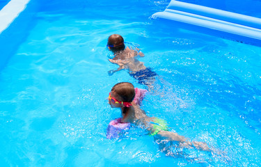 Wall Mural - boy and girl swimming in the pool in the Villa