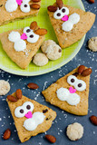 Fototapeta Zwierzęta - Easter bunny cookies scones decorated with cream and almonds like a funny bunnies face , Easter treats for kids