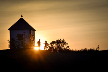 People talking near lighthouse at sundown Portor Norway