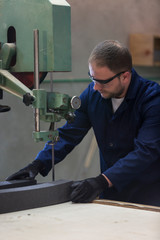 Wall Mural - Portrait of a young man in a furniture factory cutting the foam for the sofa