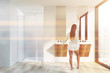 © ImageFlow - Woman in modern bathroom with shower and sink