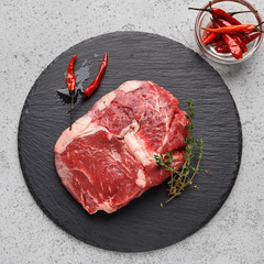 Wall Mural - Raw beef steak on black board, top view