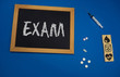 © taiga - wooden tablet on blue medical table with the word EXAM
