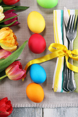  Festive table setting for Easter with fork, knife and tulip on table