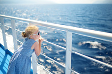 Adorable Young Girl Enjoying Ferry Ride Staring At The Deep Blue Sea. Child Having Fun On Summer Family Vacation In Greece.