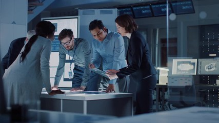 Fototapete - Engineers Meeting in Technology Research Laboratory: Engineers, Scientists and Developers Gathered Around Illuminated Conference Table, Talking and Finding Solution. Industrial Design Facility 