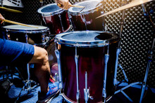 Man Playing The Drum Set With Wooden Drumsticks And Bass Drum With Foot In Music Room