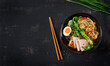 Miso Ramen Asian noodles with egg, pork and pak choi cabbage in bowl on dark background. Japanese cuisine. Top view. Flat lay
