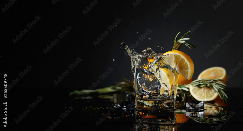 Cocktail gin-tonic with lemon slices and twigs of rosemary. - obrazy, fototapety, plakaty 