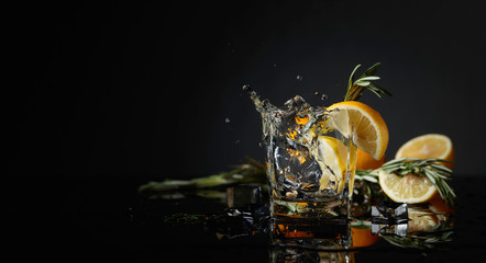 Wall Mural - Cocktail gin-tonic with lemon slices and twigs of rosemary.