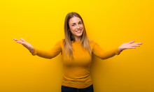 Young Woman On Yellow Background Presenting And Inviting To Come With Hand
