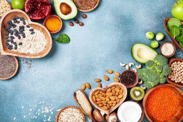 Wall Mural - Healthy food background from fruits, vegetables, cereal, nuts and superfood. Dietary and balanced vegetarian eating products on kitchen table top view.