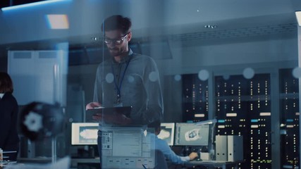 Fototapete - In Technology Research Facility: Chief Engineer Stands in the Middle of the Lab and Uses Tablet Computer. Team of Engineers, Developers Work on Engine Design Use Digital Whiteboard and Computers