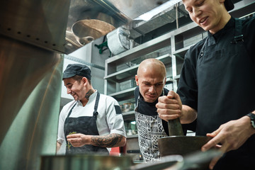 I'm watching you Strict chef in apron looking carefully how his assistant working at restaurant kitchen